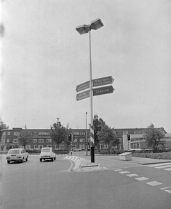 857826 Afbeelding van een lantaarnpaal met wegwijzers op het Eykmanplein te Utrecht. Op de achtergrond de huizen aan de ...